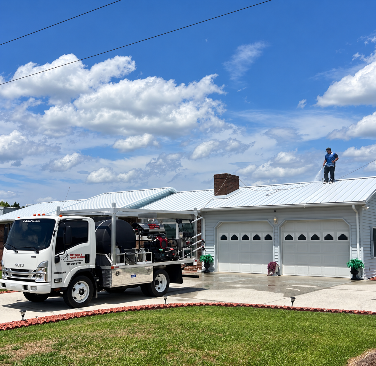 A+ Pressure Washing crew truck and technician pressure washing a home roof in Wallace, NC